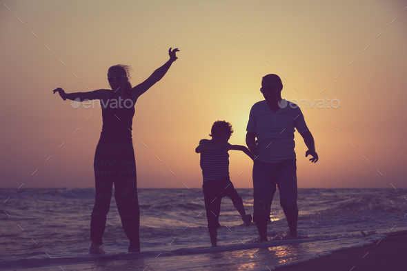 Father mother and son playing on the beach at the sunset time. - Stock Photo - Images