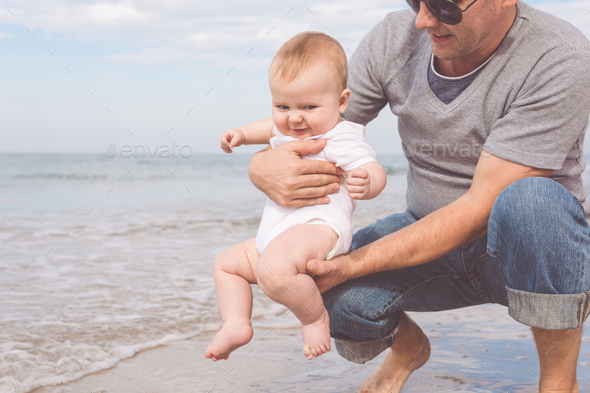 Father and son playing on the beach at the day time. - Stock Photo - Images