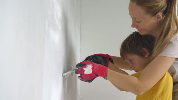 A Young Woman and Her Son are Doing a Walls Renovation in Their Home alt