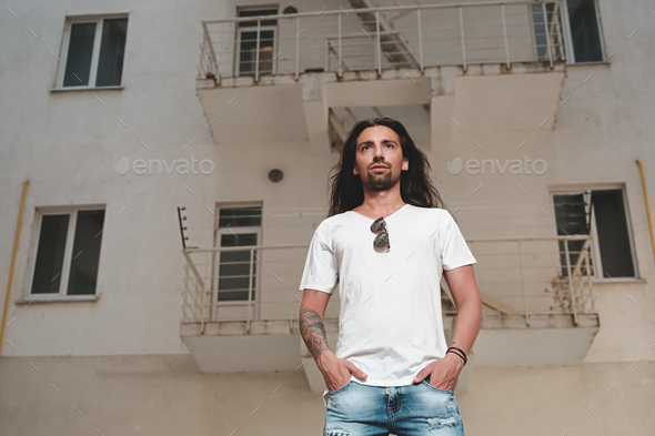Portrait confident man looking straight with hands in pockets - Stock Photo - Images