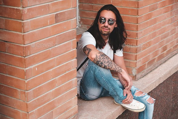 Attractive young man wearing sunglasses with tattoos - Stock Photo - Images