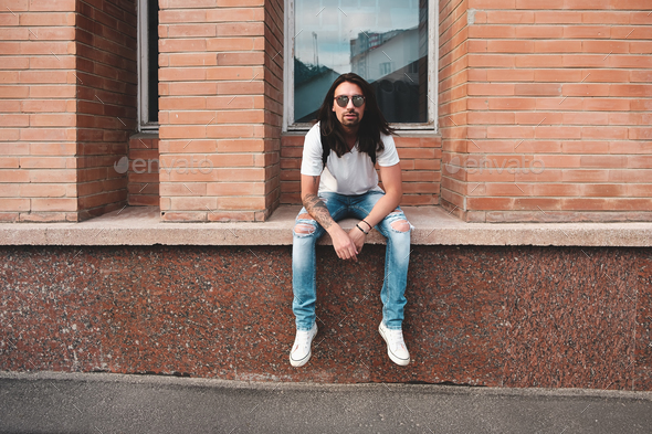 Portrait attractive man near window on urban background - Stock Photo - Images