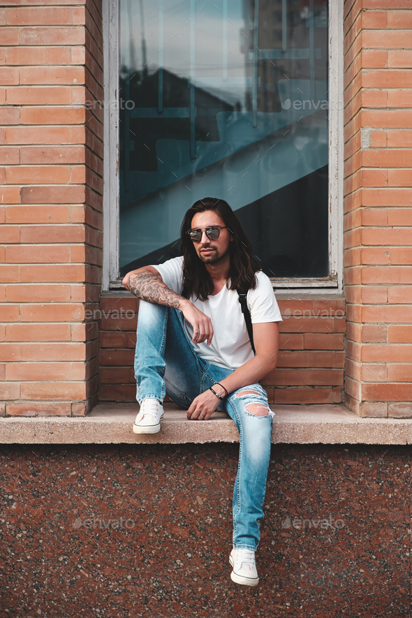 Portrait attractive man near window on urban background - Stock Photo - Images