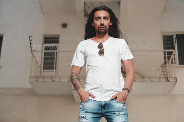 Portrait confident man looking straight with hands in pockets - Stock Photo - Images