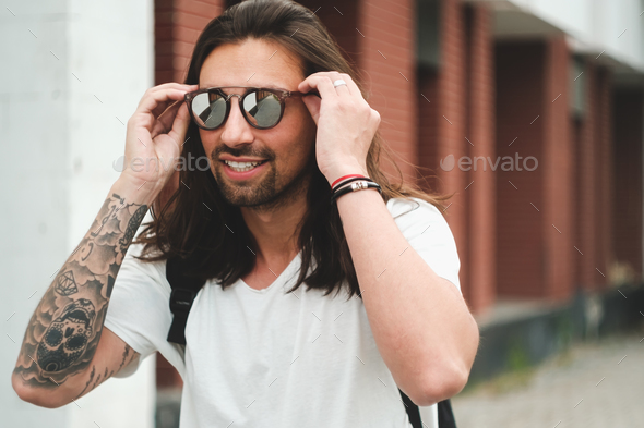 Portrait attractive man with sunglasses on urban background smil - Stock Photo - Images