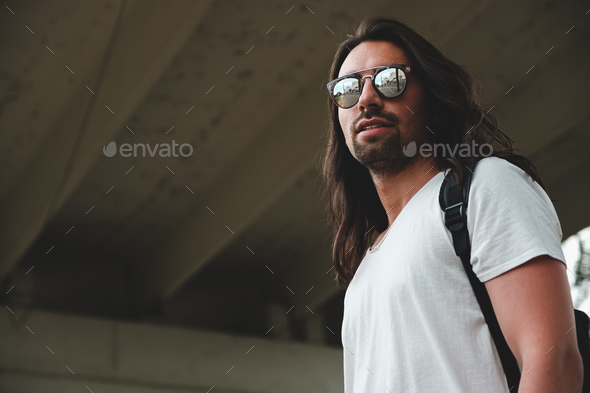 Model wearing fashionable sunglasses reflecting the city - Stock Photo - Images