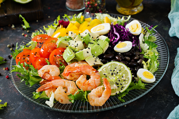 Grilled shrimps and fresh vegetable salad - avocado, tomato, black beans, red cabbage and paprika - Stock Photo - Images