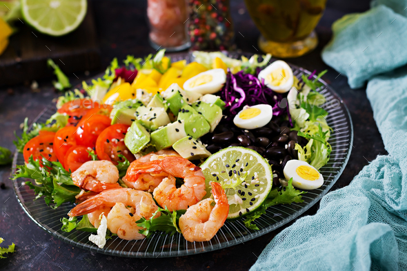 Grilled shrimps and fresh vegetable salad - avocado, tomato, black beans, red cabbage and paprika - Stock Photo - Images