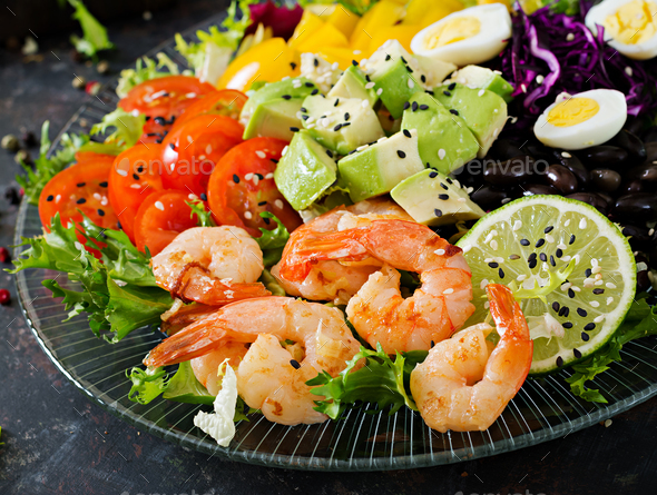 Grilled shrimps and fresh vegetable salad - avocado, tomato, black beans, red cabbage and paprika - Stock Photo - Images
