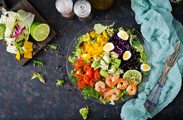 Grilled shrimps and fresh vegetable salad - avocado, tomato, black beans, red cabbage and paprika. - Stock Photo - Images