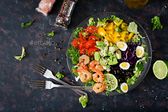 Grilled shrimps and fresh vegetable salad - avocado, tomato, black beans, red cabbage and paprika. - Stock Photo - Images