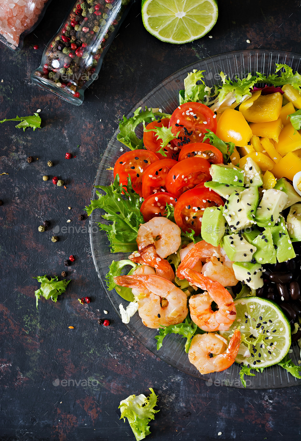 Grilled shrimps and fresh vegetable salad - avocado, tomato, black beans, red cabbage and paprika. - Stock Photo - Images