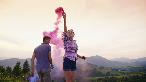 Friends - a Man and a Woman Are Playing with Colored Smoke alt