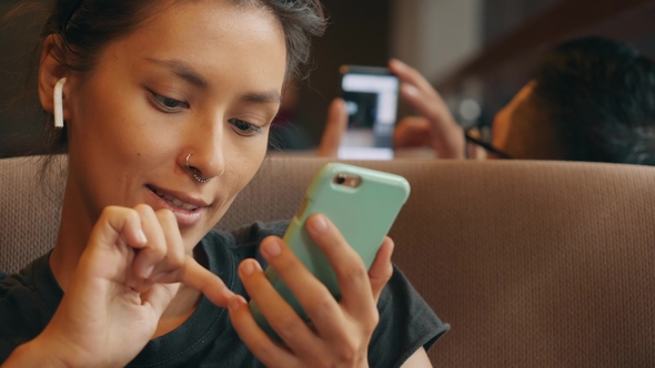 Young Mixed Race Woman Listening Music with Wireless Headphones People Using Mobile Phones and in