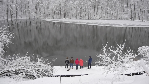 Group of Tourists on the Shore of a Winter Lake