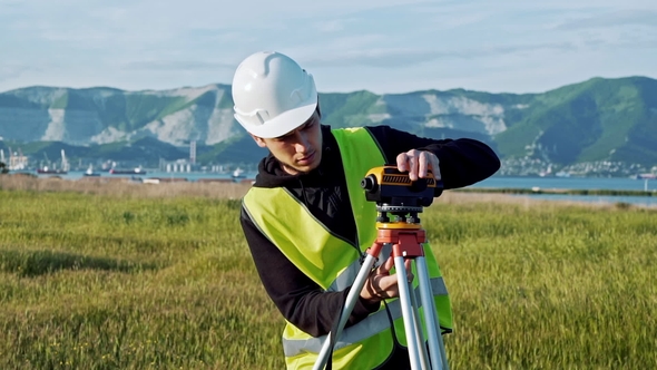 Surveyor Engineer Is Measuring Level on Construction Site alt