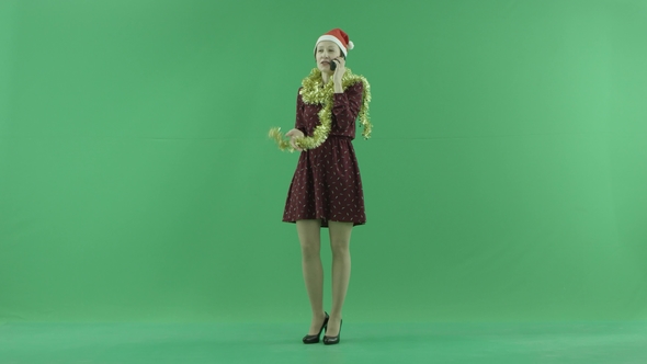 A Young Christmas Woman Talking on Her Phone on the Green Screen