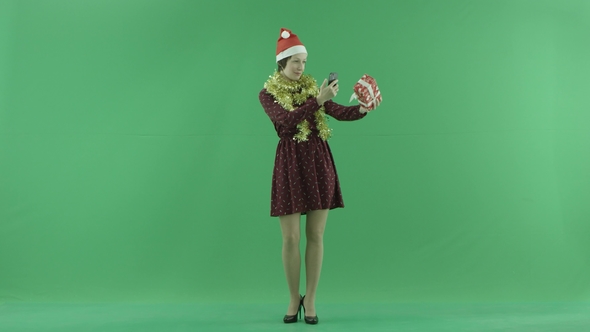 A Young Woman Is Taking Photos of Her Christmas Gift on the Green Screen