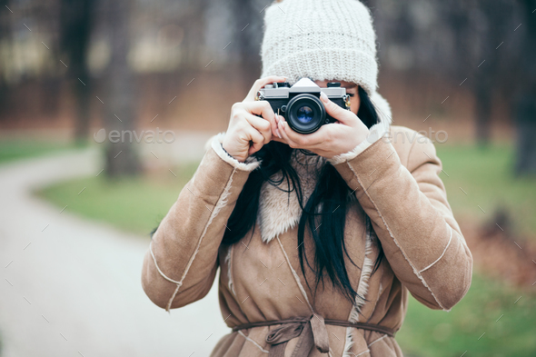 Female photographer taking pictures outdoors with a vintage camera - Stock Photo - Images