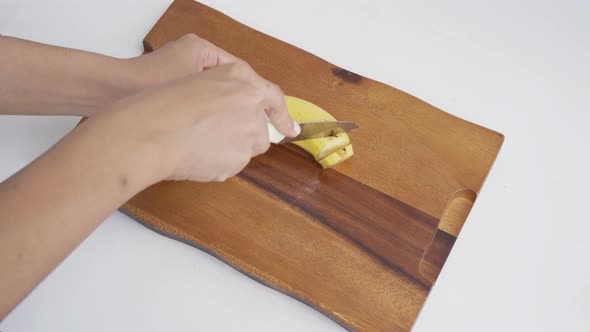 Hands cutting banana. Raw organic healthy food fruit. Grocery and supermarket