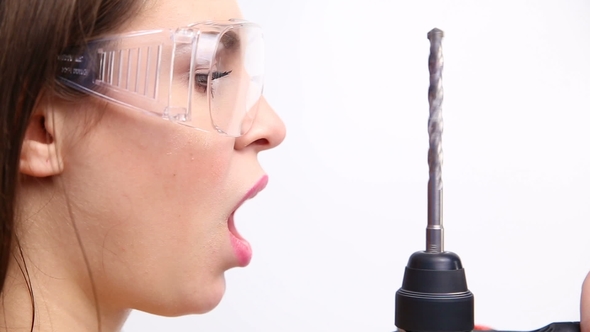 Sexy Girl Posing with a Drill on a White Studio. Concept - Beauty and Strength, Feminism alt