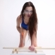 Sexy Woman in a Blue Swimsuit Sawing Wooden Beams with Saw. the Beautiful Girl Moves - VideoHive Item for Sale