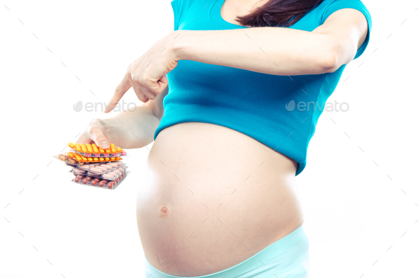 Woman in pregnant showing stack of medical pills or supplements - Stock Photo - Images