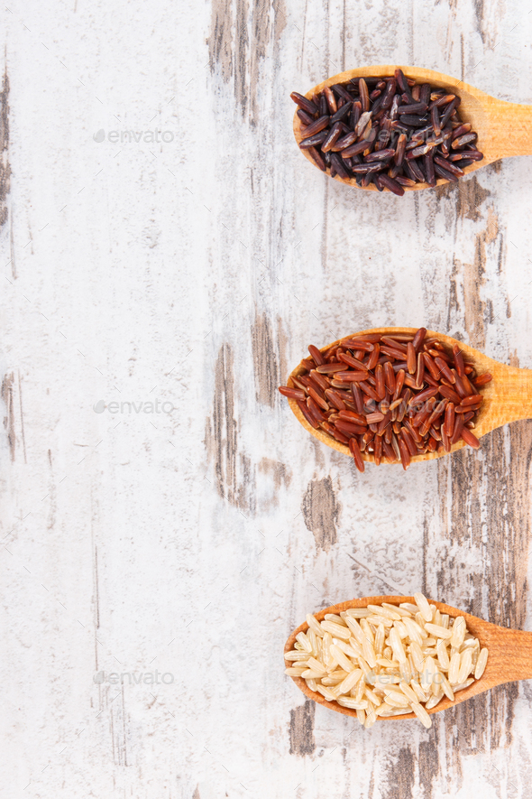 Brown, black and red rice on wooden spoons, healthy gluten free food concept, copy space for text - Stock Photo - Images