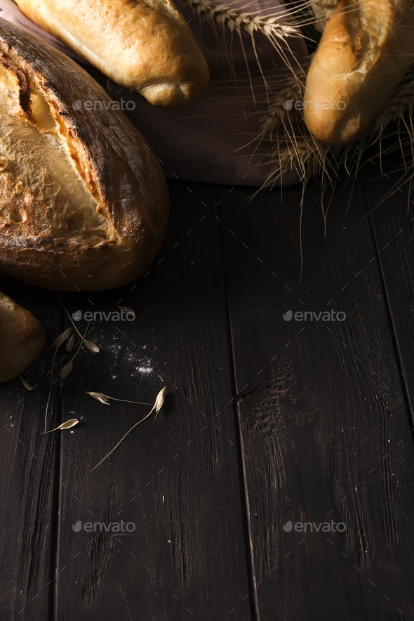 Bakery - gold rustic crusty loaves of bread and buns on black chalkboard background. - Stock Photo - Images