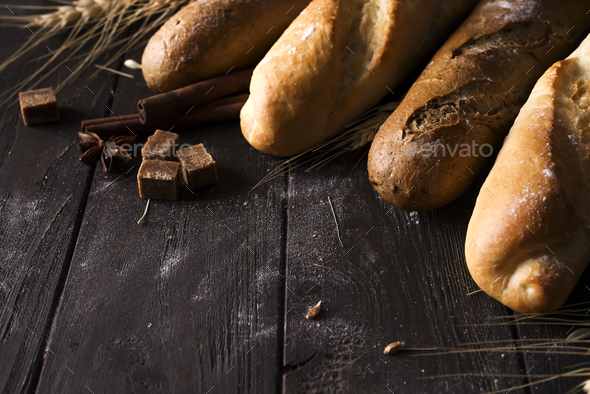 Bakery - gold rustic crusty loaves of bread and buns on black chalkboard background. - Stock Photo - Images