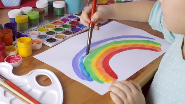 Cute Young Girl Painting Colorful Rainbow at Home