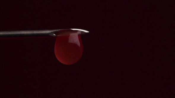 Drops of Blood Leaking From the Needle of a Syringe Piston. Drop of Blood Falling From Syringe on alt
