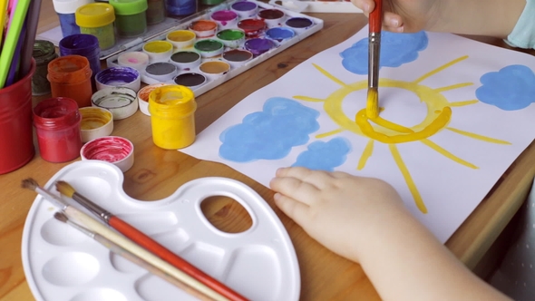 Cute Young Girl Draws Yellow Sun on White Paper