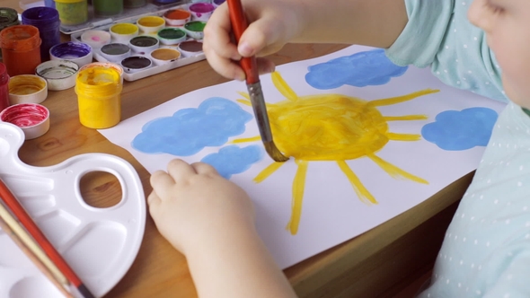 Young Girl Drawing Yellow Sun and Blue Clouds