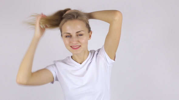Beautiful Woman Collects Her Hair in a Ponytail