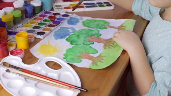 Cute Girl Painting Brown Trees with Green Leaves on White Paper