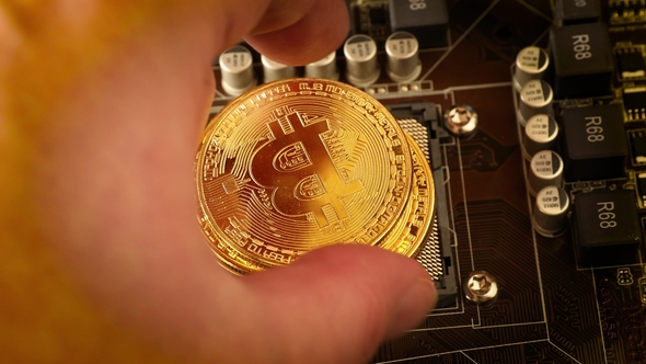 Gold Bit Coin BTC Coins on the Motherboard. Bitcoin Is a Worldwide Cryptocurrency alt