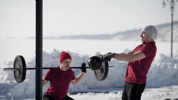 Two Athletic Crossfit Sportsmen Training on the Nature in Winter alt
