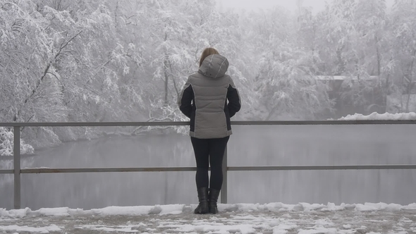 Lonely Woman Near the Lake in Winter