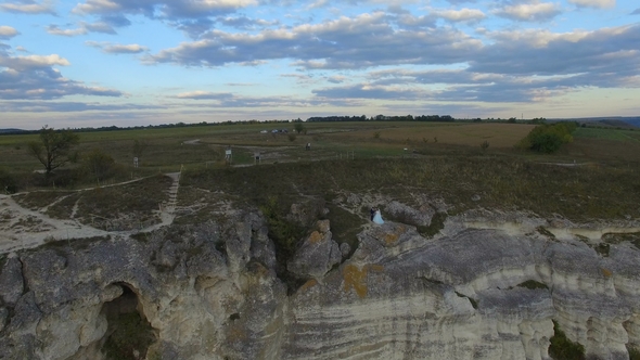 Great Sunset on the Lake Between the Mountains. A Couple Hugging at the Edge of the Cliff alt