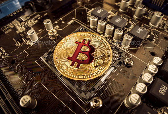 Gold Bit Coin BTC coins on the motherboard. Bitcoin is a worldwi