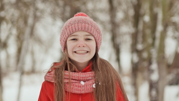 A Young Schoolgirl Joyfully Throws a Snowball and Breaks It with a Palm When It Falls alt