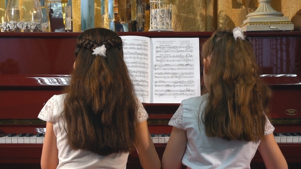 Cheerful Beautiful Small Girls Play Piano Together