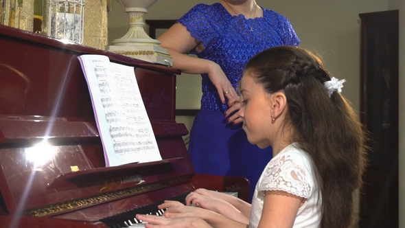 Mother and Daughters Learn To Play Piano Together in Home