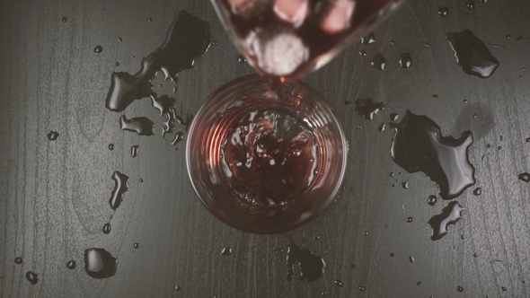 Red Wine Diluted with Water and Ice Is Poured Into a Glass