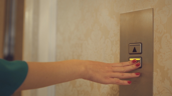Female Hand Pushing Button for Calling Elevator in Apartment Corridor alt