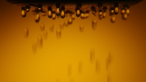 Crystal Clear Droplets Fall Slowly From a Shower Nozzle in a Brown Bathroom