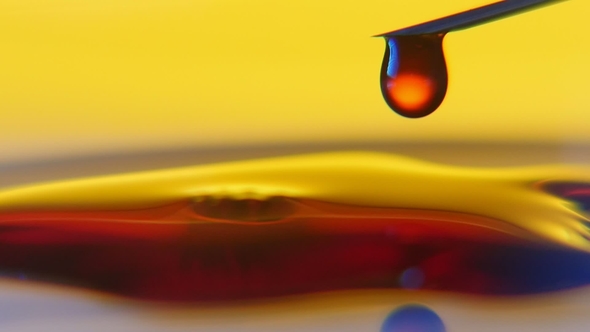 Red Blood Drops Fall on Liquid Surface and Slide Aside in the Yellow Background