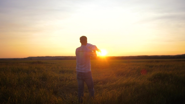 Dad Plays with Kid in Flying Airplane at Sunset Orange Sun alt