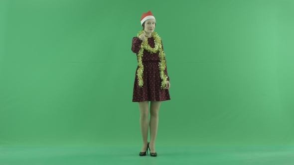 A Young Christmas Woman Calls To the Viewer on the Green Screen